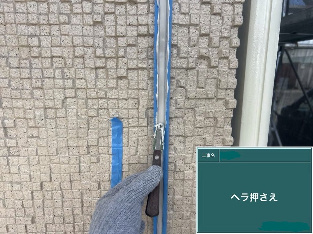 ヘラでコーキングを押さえる作業